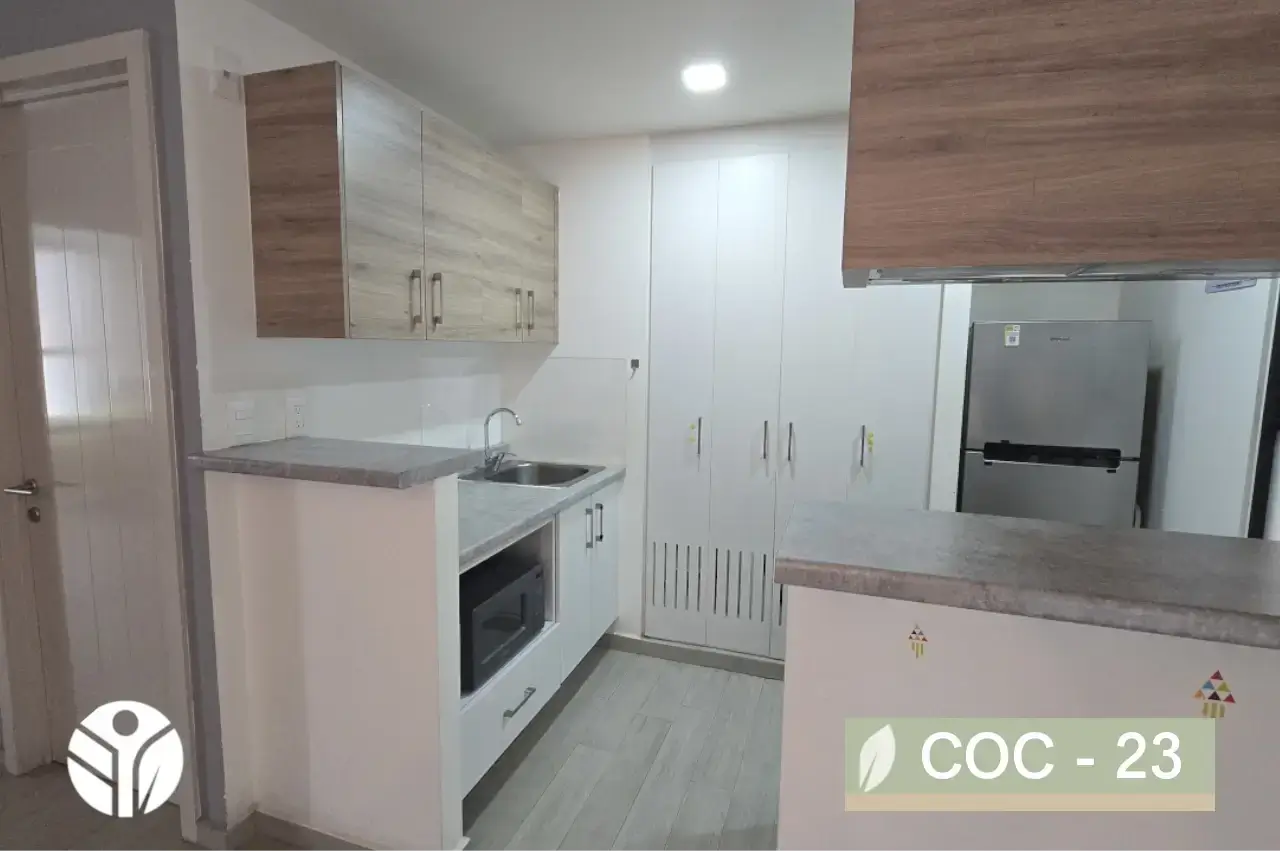 Cocina compacta blanca con barra, cubierta gris, alacena alta y nicho para microondas, Costa Rica