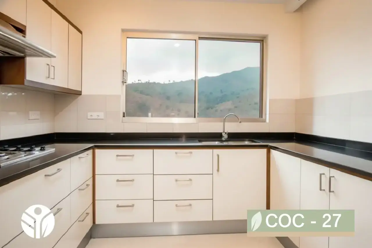 Cocina en U blanca con tiraderas de acero, cubierta tipo granito negro y fregadero bajo ventana, Costa Rica