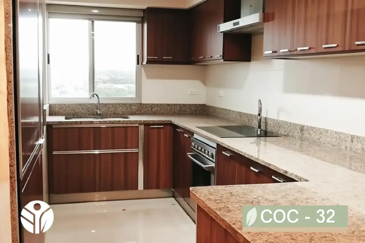 Cocina en L con muebles en madera oscura, horno empotrado, campana de acero y cubierta tipo granito beige, Costa Rica