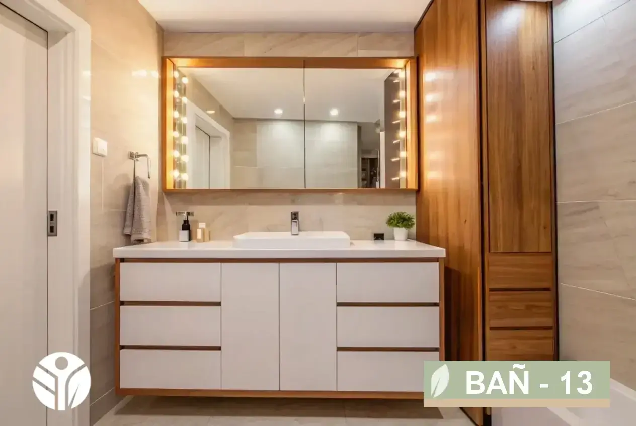 Mueble de baño con frentes blancos, cubierta blanca, espejo con luces tipo camerino y torre en madera